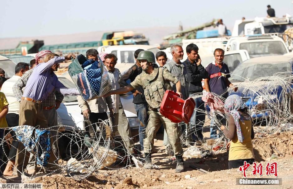 土耳其士兵助叙利亚库尔德难民过境避难(高清